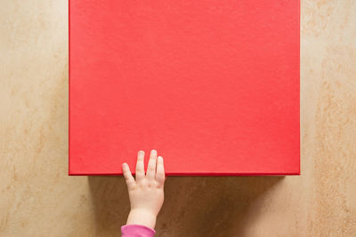 Close-up of hand holding red wall