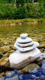 Close-up of stone stack on rock by lake