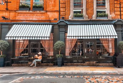 Man walking on sidewalk by building in city