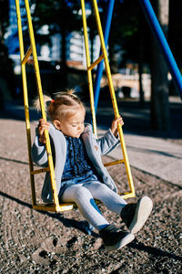 Portrait of boy swinging at playground