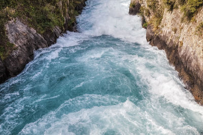 High angle view of waves splashing on rocks