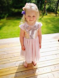 Cute girl standing on wood