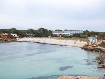 Scenic view of sea by buildings against sky