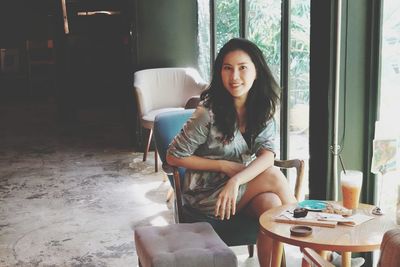 Portrait of woman sitting on sofa at home