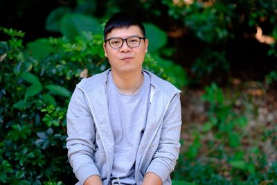 Portrait of young man sitting at park