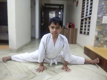 Portrait of boy sitting on floor at home