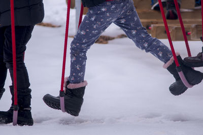 Low section of people playing at playground during winter