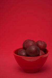 Close-up of raspberries in bowl against red background