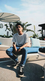 Portrait of young man sitting on wall