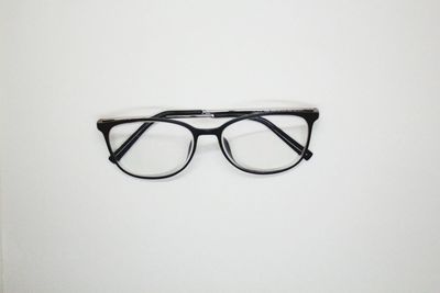 Close-up of eyeglasses on table against white background