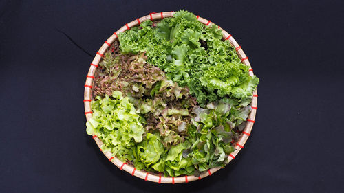 High angle view of chopped vegetables in bowl on table against black background