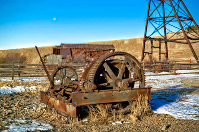 Old rusty wheel against clear blue sky