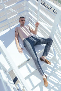 Portrait of young man standing on staircase
