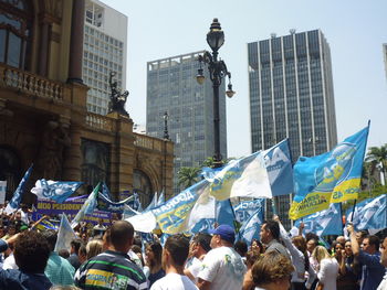 People at town square against sky in city