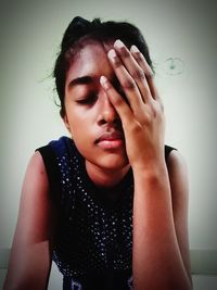 Portrait of boy covering face against wall