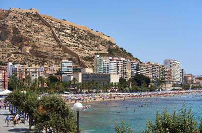 Buildings by sea against mountain