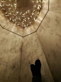 Low section of man standing on tiled floor