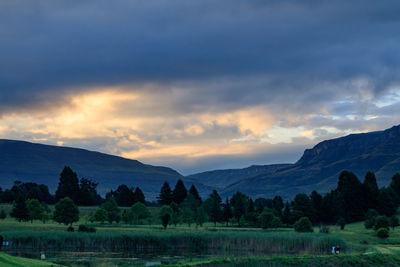 Scenic view of river by mountains against sky