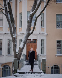 Rear view of man standing in city during winter