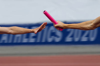 Cropped hands passing equipment during race