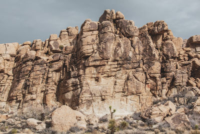 Low angle view of rock formation on land against sky