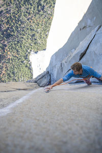 Athlete clipping climbing rope while lead climbing changing corners