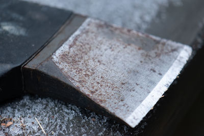 High angle view of rusty metal axe on table