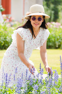 Young woman wearing sunglasses on red flowering plants