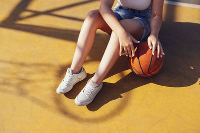 Low section of woman playing basketball