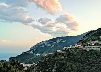 Scenic view of town by mountains against sky