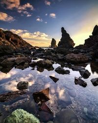 Scenic view of rocks against sky during sunset