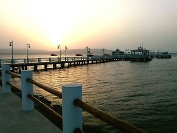 Pier on sea at sunset