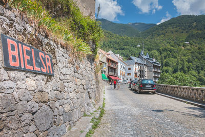 Road by building against mountains