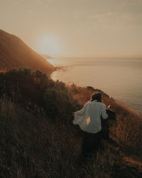 Rear view of man looking at sunset