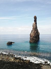 Rock formation on sea against sky