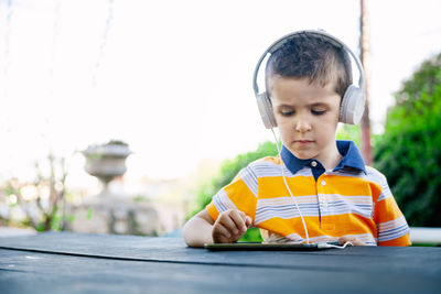 Boy looking at camera while sitting on table