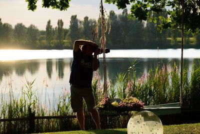Man photographing by lake