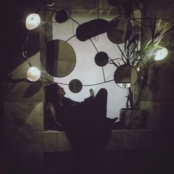 Digital composite of illuminated lamp hanging on ceiling