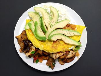 Directly above shot of egg and mushrooms in plate against gray background