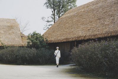 Rear view of woman walking by building