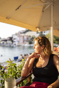 Woman looking away while sitting in water