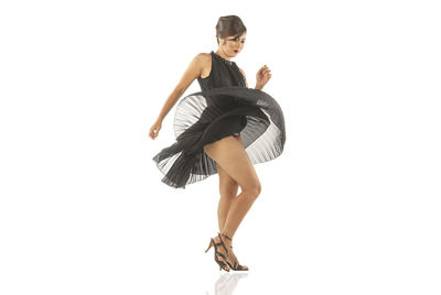 Full length of woman dancing against white background