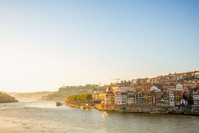 Scenic view of river by buildings against sky