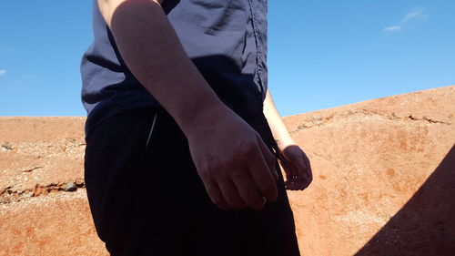 Close-up of woman standing against blue sky