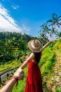 Rear view of woman standing on field against sky