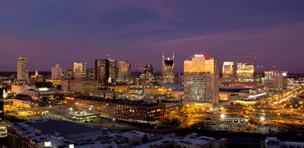 Illuminated cityscape against sky at night