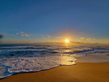 Scenic view of the sun rising over the sea against the clouds during sunrise 