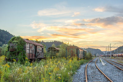 Train on railroad track against sky during sunset