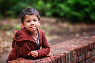 Little boy posing in a brick wall