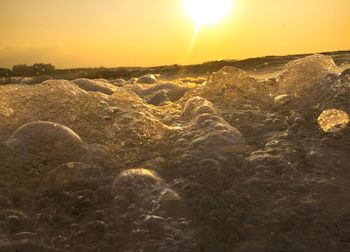 Water surface view of sea against sky during sunset